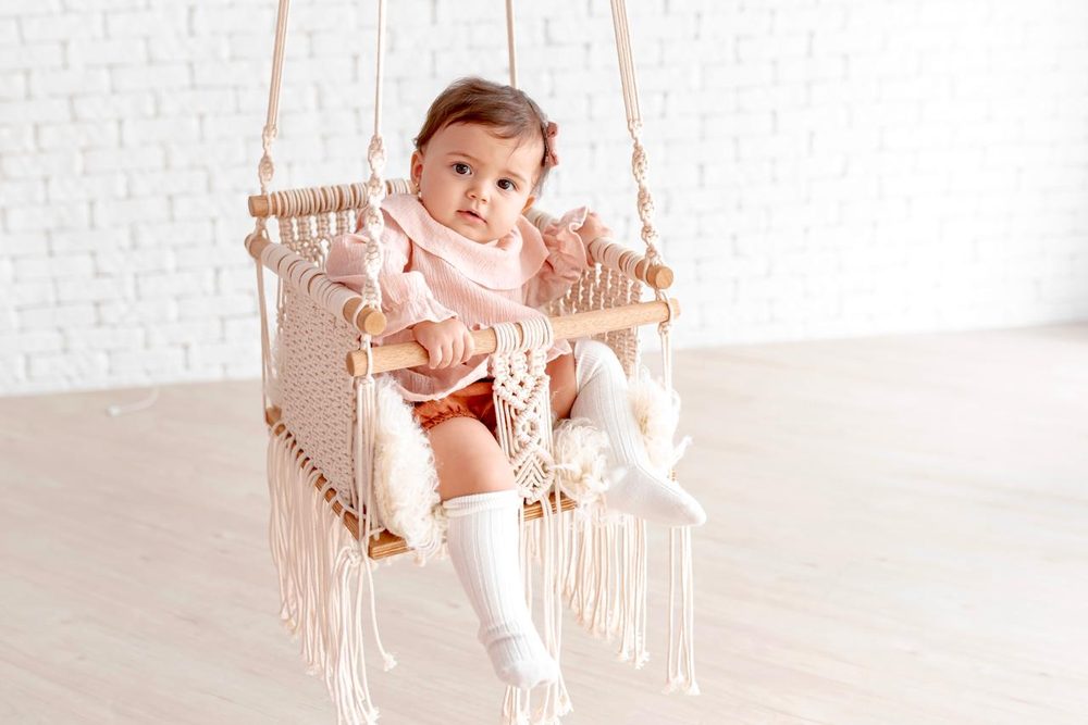 Bebê em um balanço de macramê